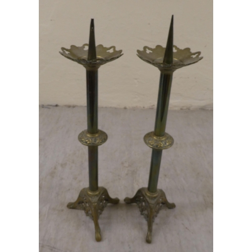 10 - A pair of Art Nouveau brass pricket candlesticks, on a pierced, splayed tripod plinths  21