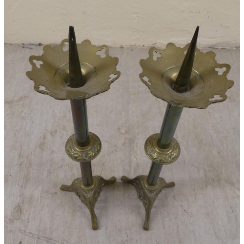 10 - A pair of Art Nouveau brass pricket candlesticks, on a pierced, splayed tripod plinths  21