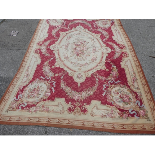 177 - A 20thC wool tapestry, depicting a central floral bouquet, on a red and cream ground  160