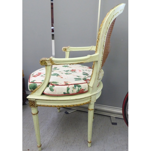 211 - An early 19thC Continental inspired overpainted open arm chair, the wicker back and seat, raised on ... 