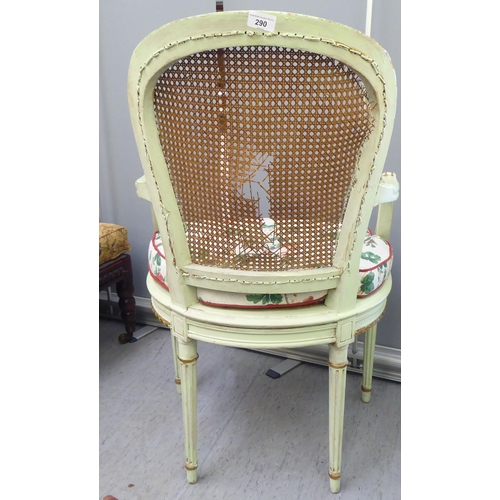 211 - An early 19thC Continental inspired overpainted open arm chair, the wicker back and seat, raised on ... 