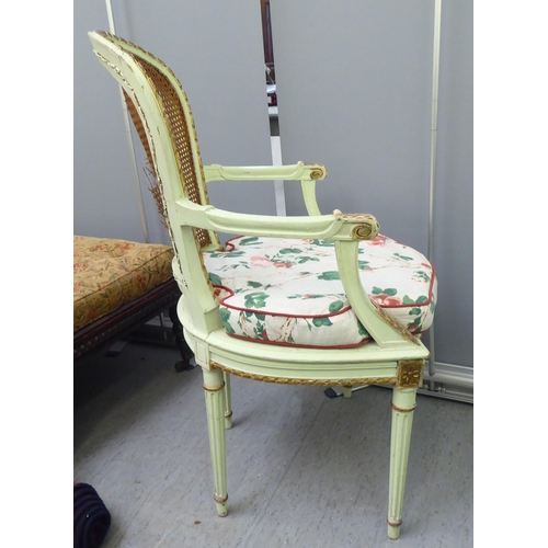 211 - An early 19thC Continental inspired overpainted open arm chair, the wicker back and seat, raised on ... 