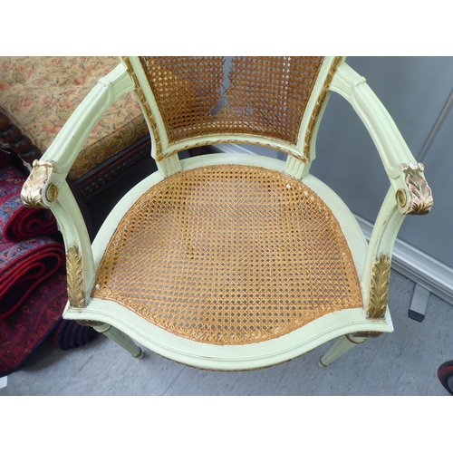 211 - An early 19thC Continental inspired overpainted open arm chair, the wicker back and seat, raised on ... 