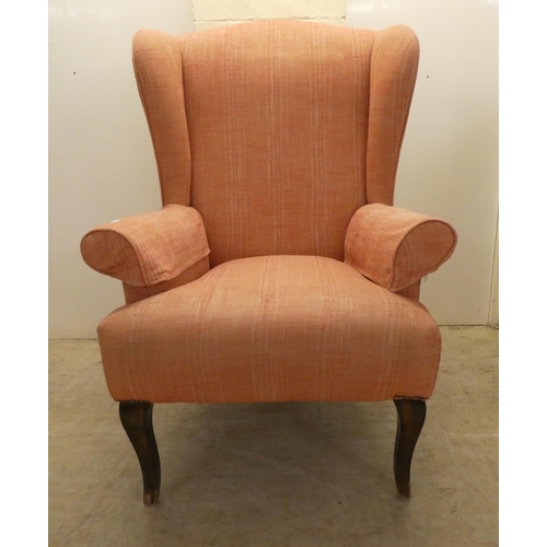 22 - A John Lewis red fabric upholstered, enclosed armchair, raised on sabre forelegs