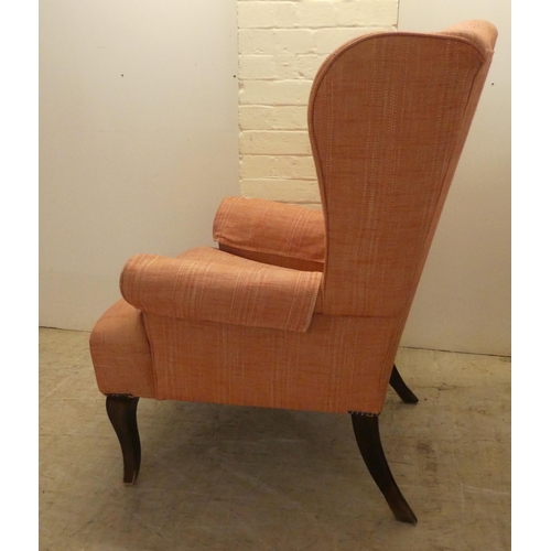 22 - A John Lewis red fabric upholstered, enclosed armchair, raised on sabre forelegs