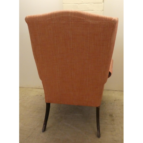 22 - A John Lewis red fabric upholstered, enclosed armchair, raised on sabre forelegs