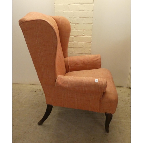 22 - A John Lewis red fabric upholstered, enclosed armchair, raised on sabre forelegs