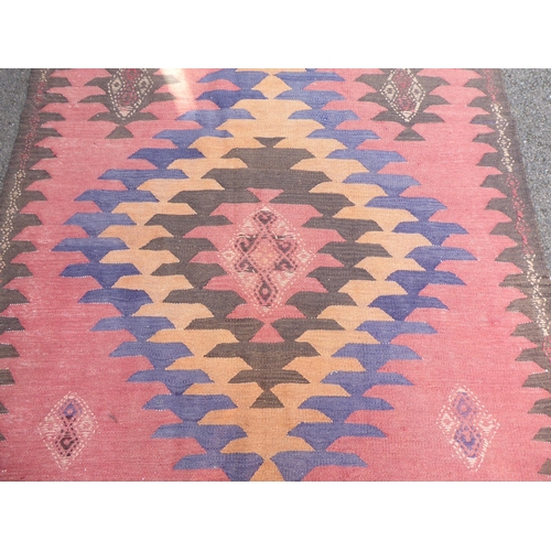 220 - A Turkish Kelim carpet, decorated with geometric patterns, on a red ground  152