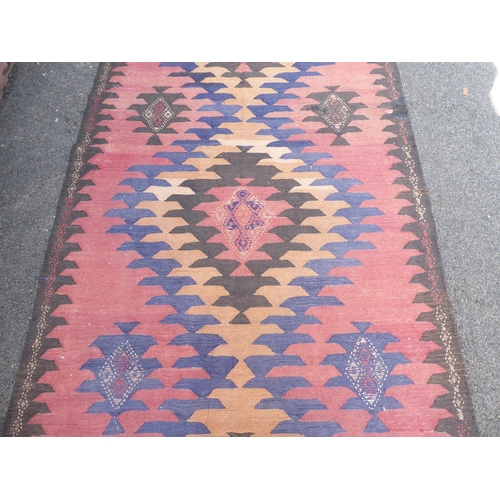 220 - A Turkish Kelim carpet, decorated with geometric patterns, on a red ground  152