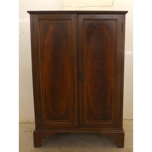 24 - An Edwardian mahogany two door side cabinet, raised on bracket feet  41