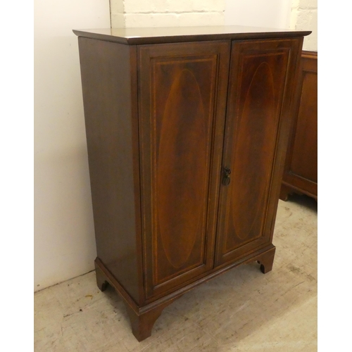 24 - An Edwardian mahogany two door side cabinet, raised on bracket feet  41