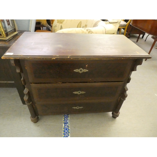 253 - A mid 20thC coromandal effect pine three drawer dressing chest, on turned legs  30