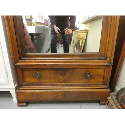 254 - A late Victorian flame mahogany finished wardrobe with a moulded cornice, over a mirrored door and s... 