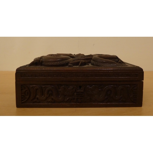 270 - An Indian carved hardwood casket, featuring a dragon on the hinged lid, enclosing a compartmented in... 