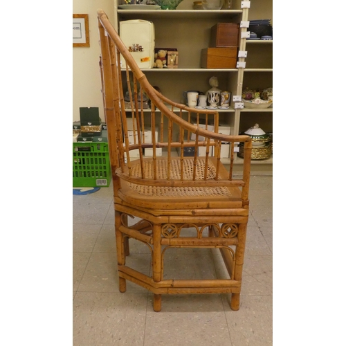 279 - A mid 20thC Brighton Pavilion design bamboo chair with swept open arms and a caned seat, raised on t... 