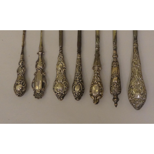 298 - Victorian and later steel button hooks and shoe horns, on decoratively moulded silver handles  ... 