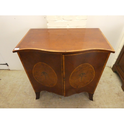 37 - An Edwardian crossbanded yew and mahogany serpentine front, two door cabinet, enclosing two open she... 