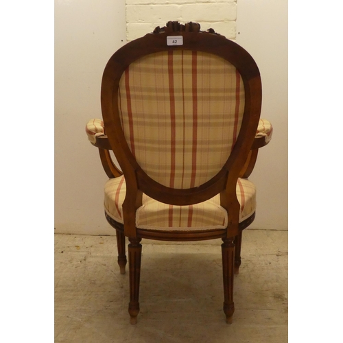 42 - A 20thC French inspired, carved mahogany framed open arm salon chair, raised on fluted forelegs