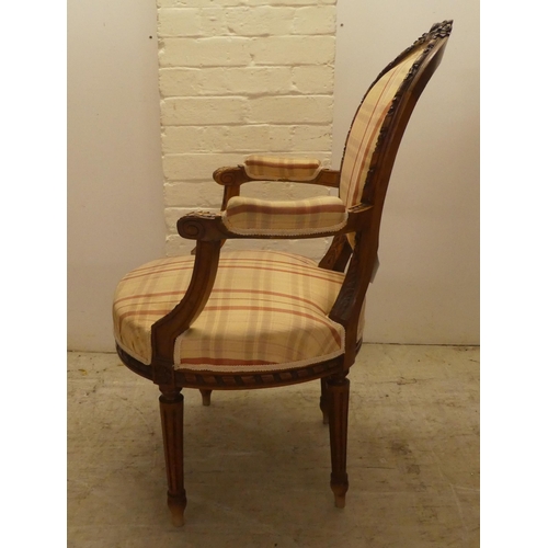 42 - A 20thC French inspired, carved mahogany framed open arm salon chair, raised on fluted forelegs