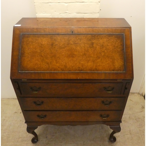 47 - A 1930s burr walnut finished bureau, the fall-flap over three drawers, raised on shell carved cabrio... 