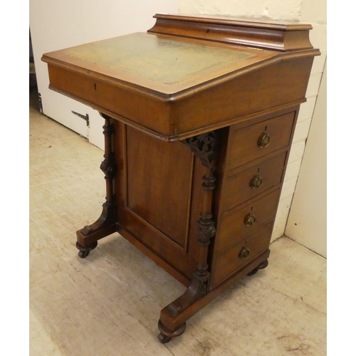 51 - A late Victorian mahogany Davenport, having a sloping, hinged lid with a tooled green hide scriber, ... 