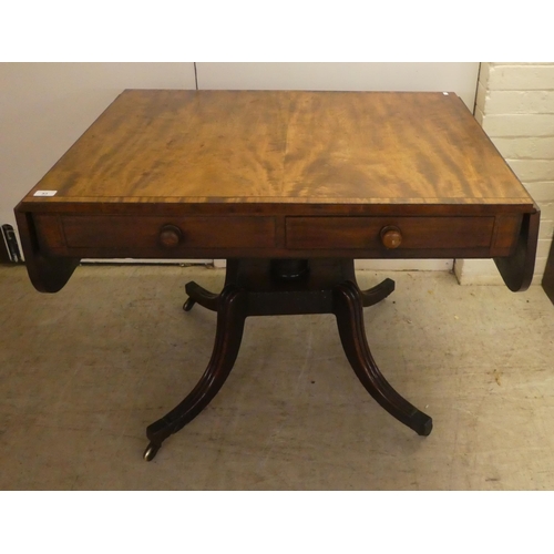 53 - A Regency ebony inlaid mahogany sofa table with two frieze drawers, raised on splayed, sabre legs an... 