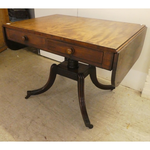 53 - A Regency ebony inlaid mahogany sofa table with two frieze drawers, raised on splayed, sabre legs an... 