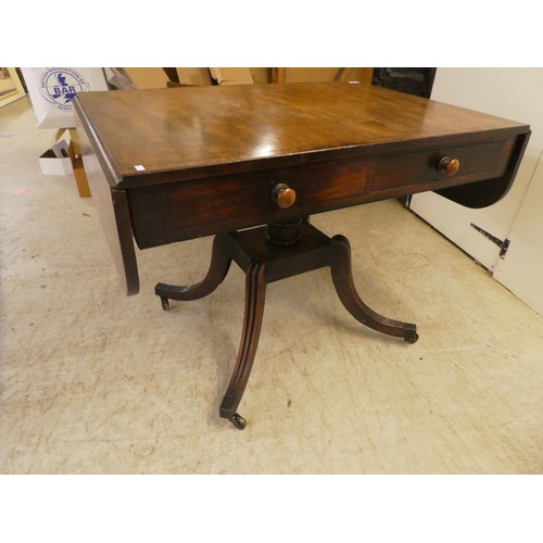 53 - A Regency ebony inlaid mahogany sofa table with two frieze drawers, raised on splayed, sabre legs an... 