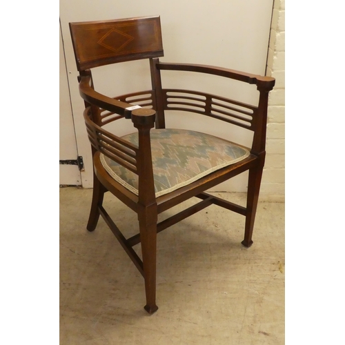 61 - An Edwardian satinwood inlaid mahogany, horseshoe shaped chair with a slatted back, raised on square... 