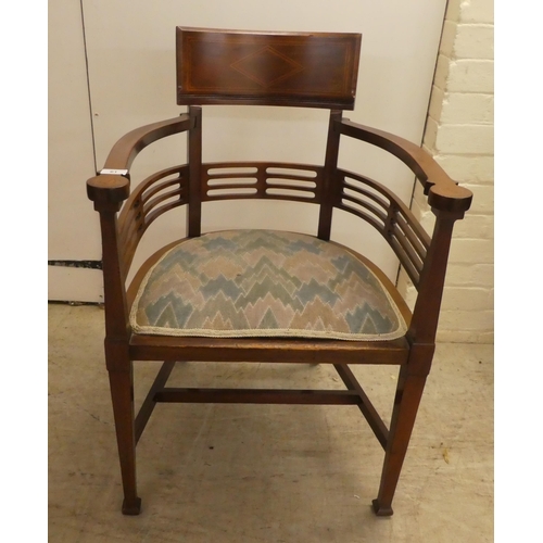 61 - An Edwardian satinwood inlaid mahogany, horseshoe shaped chair with a slatted back, raised on square... 