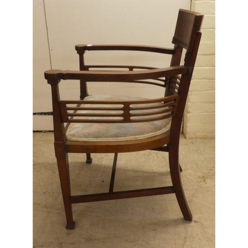 61 - An Edwardian satinwood inlaid mahogany, horseshoe shaped chair with a slatted back, raised on square... 