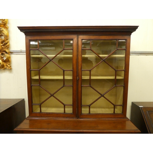 76 - An Edwardian mahogany cabinet bookcase, the upper section with two glazed doors, over two panelled d... 