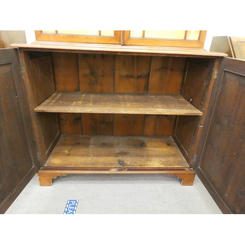 76 - An Edwardian mahogany cabinet bookcase, the upper section with two glazed doors, over two panelled d... 