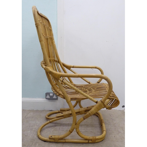 102 - A caned and bound wicker, open arm easy chair, on a freeflowing support