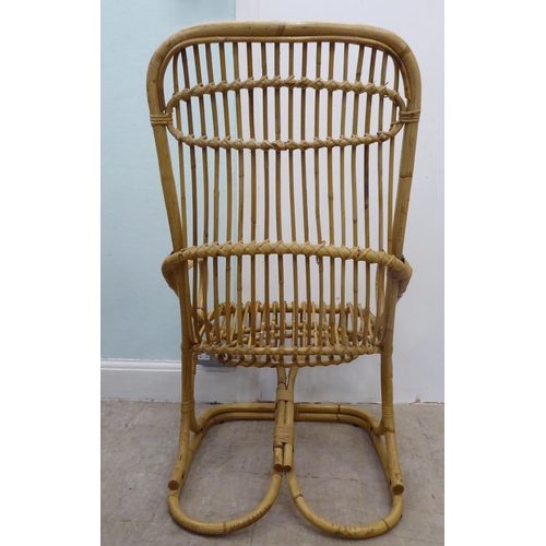 102 - A caned and bound wicker, open arm easy chair, on a freeflowing support