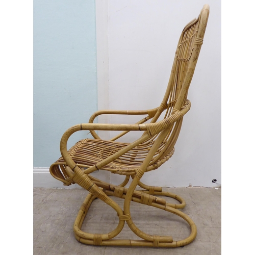 102 - A caned and bound wicker, open arm easy chair, on a freeflowing support