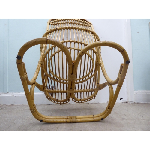 102 - A caned and bound wicker, open arm easy chair, on a freeflowing support