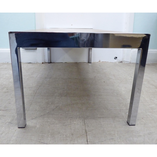 104 - A 1980s oak coffee table, raised on chromium plated ends and square legs  bears an indistinct stamp ... 