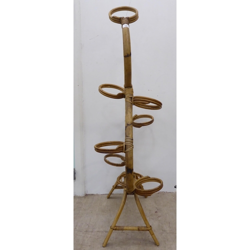 109 - A circa 1960/70s bamboo wicker bound plant stand of freeflowing form, accommodating seven pots  53