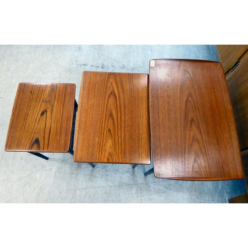 114 - A nesting set of three circa 1960s (probably Danish) teak occasional tables, raised on turned, taper... 