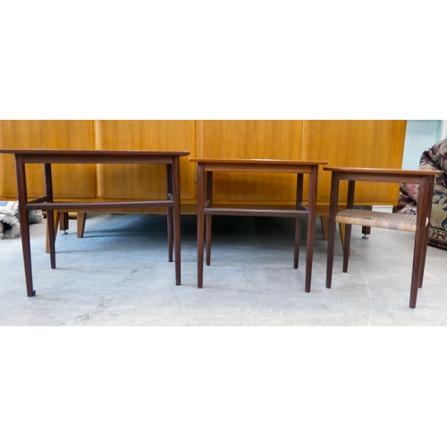 114 - A nesting set of three circa 1960s (probably Danish) teak occasional tables, raised on turned, taper... 