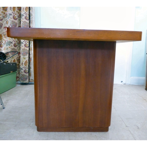 115 - A circa 1960/70s teak one-piece desk with two drawers, raised on two lozenge shaped pedestals  31