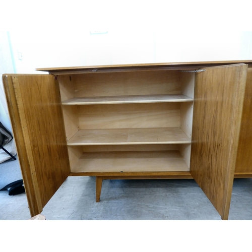 117 - A 1960/70s Produit Suisse Schweizerjabrikat teak sideboard with four doors, enclosing open shelves, ... 