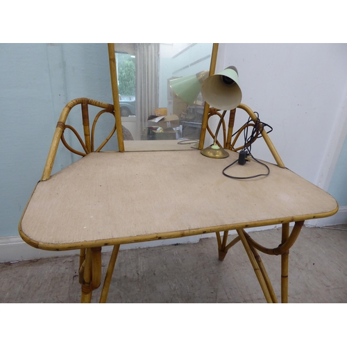 119 - A circa 1960/70s cane bound bamboo framed one-piece dressing table with a mirror, over a rattan cove... 