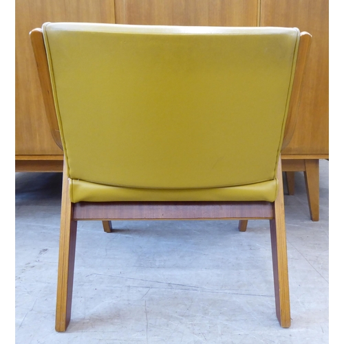 126 - A walnut framed and hide upholstered lounge chair by Neil Morris, raised on splayed legs