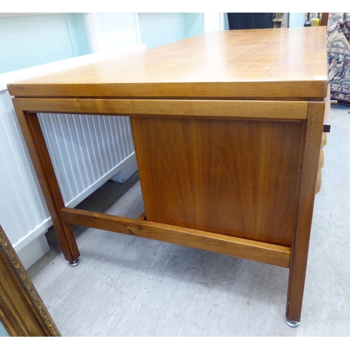 140 - A 1970s Jens Risom Design Ltd teak one piece, twin pedestal desk with an arrangement of sliding, gra... 