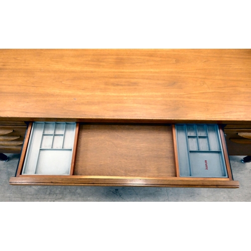 140 - A 1970s Jens Risom Design Ltd teak one piece, twin pedestal desk with an arrangement of sliding, gra... 