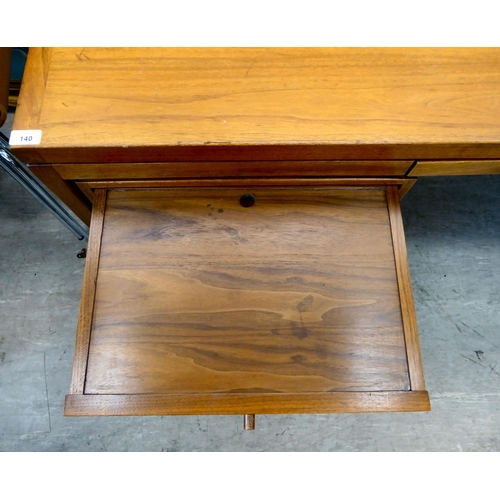 140 - A 1970s Jens Risom Design Ltd teak one piece, twin pedestal desk with an arrangement of sliding, gra... 