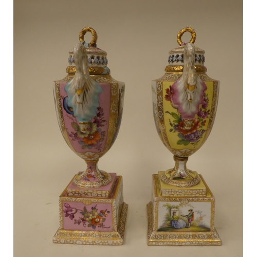 145 - A pair of Dresden porcelain, twin handled pedestal pot pourri vases, decorated in figural panels and... 