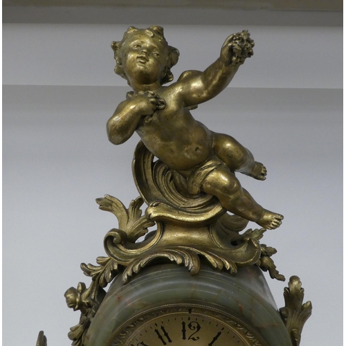 166 - A late 19thC Continental, gilded metal and green onyx cased mantel clock, featuring cavorting cherub... 